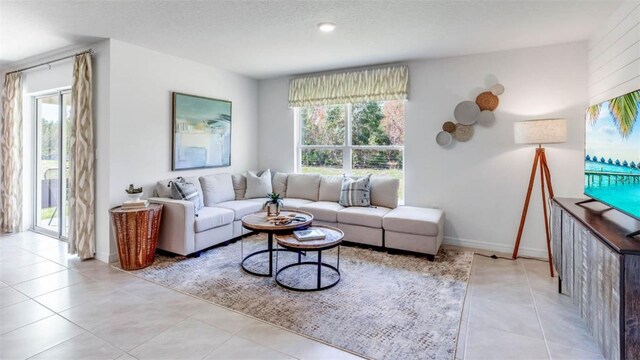 living room with a textured ceiling and light tile patterned floors