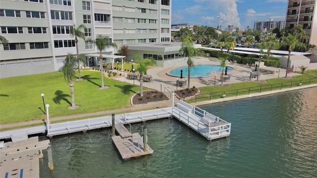 dock area featuring a lawn, a water view, a patio area, and a community pool