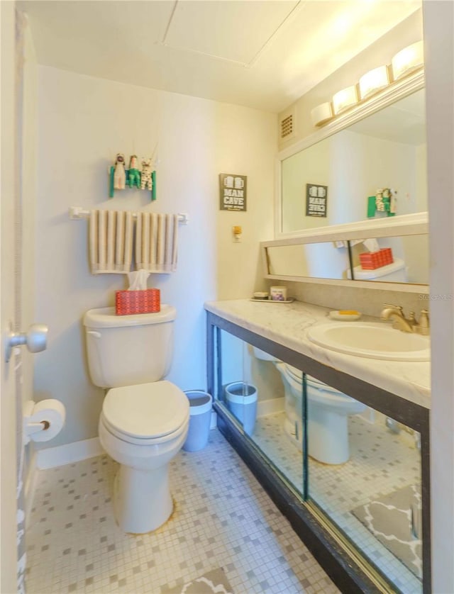 bathroom with tile patterned flooring, vanity, and toilet