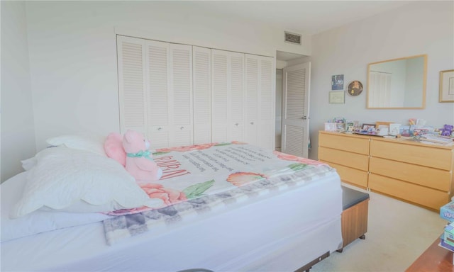 bedroom featuring a closet, visible vents, and light colored carpet