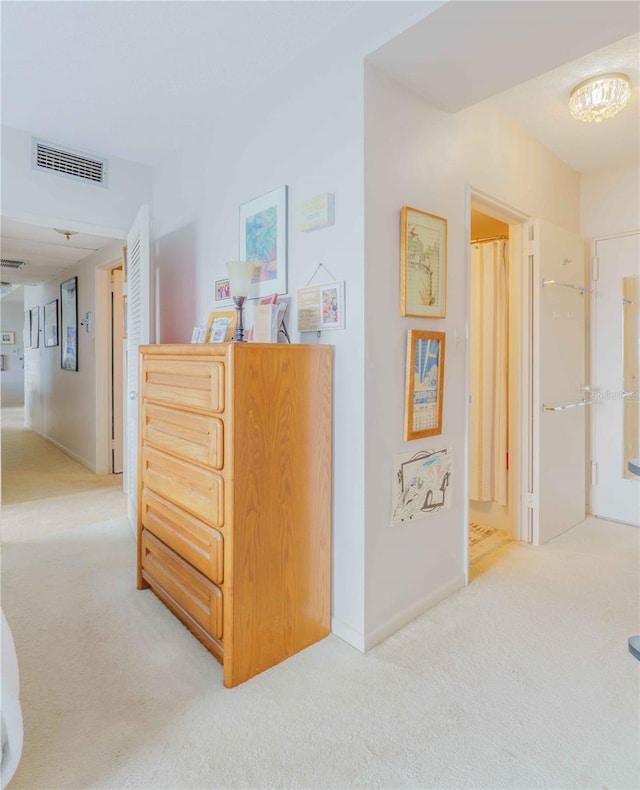 hallway with light carpet and visible vents