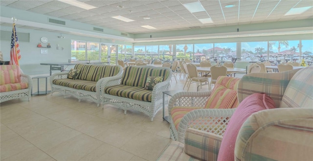 tiled living area featuring a drop ceiling and visible vents