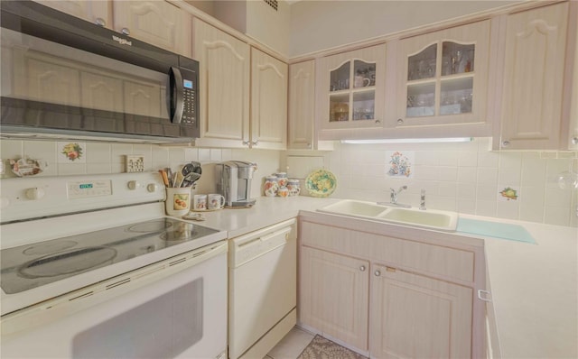 kitchen featuring white appliances, glass insert cabinets, light countertops, and decorative backsplash