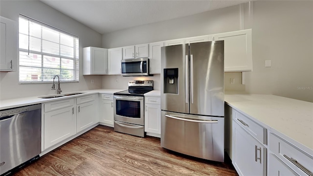 kitchen with sink, appliances with stainless steel finishes, and white cabinetry