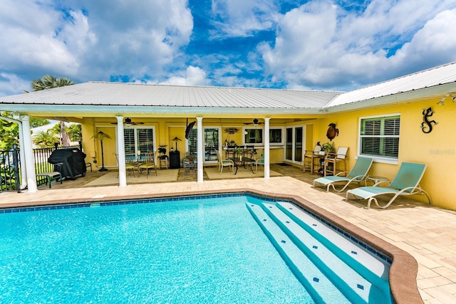 view of swimming pool with ceiling fan, a patio, and grilling area