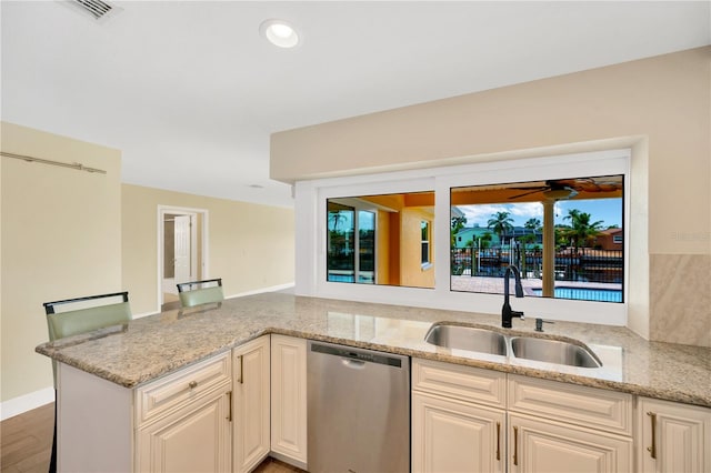 kitchen with light stone countertops, sink, stainless steel dishwasher, dark hardwood / wood-style floors, and kitchen peninsula