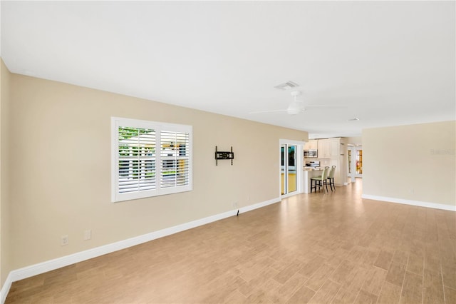 unfurnished room featuring light wood-type flooring and ceiling fan