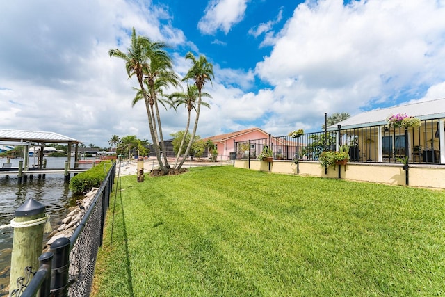 view of yard with a boat dock and a water view