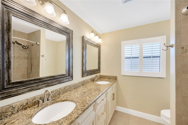 bathroom featuring tile patterned flooring, vanity, tiled shower, and toilet