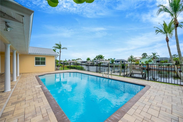 view of swimming pool with a patio area and a water view