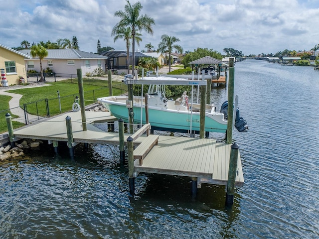 view of dock featuring a water view and a yard