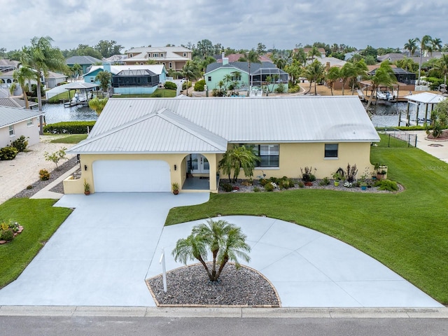 view of front of home featuring a garage, a water view, and a front lawn