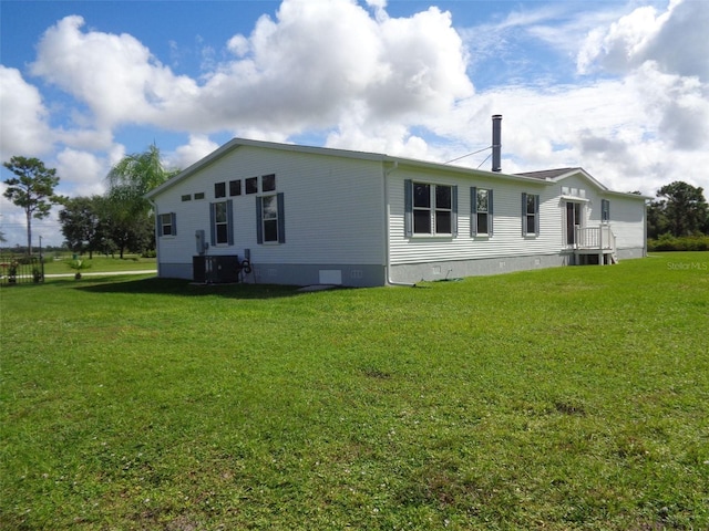 view of property exterior with a yard and central AC