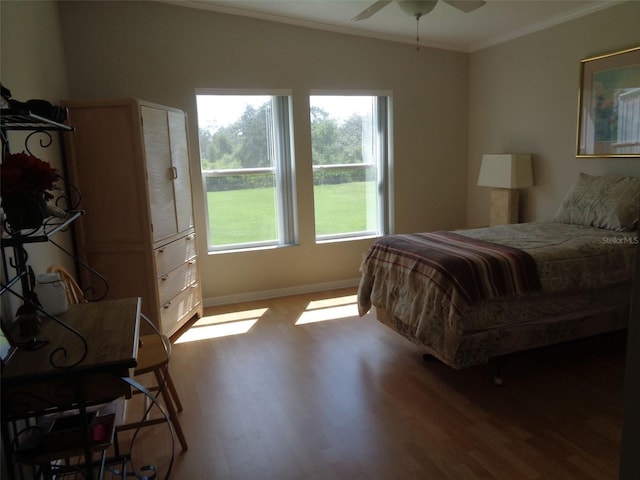 bedroom with ceiling fan, hardwood / wood-style flooring, and crown molding