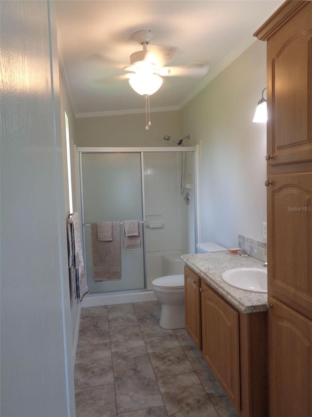 bathroom featuring a shower with shower door, ceiling fan, toilet, and vanity