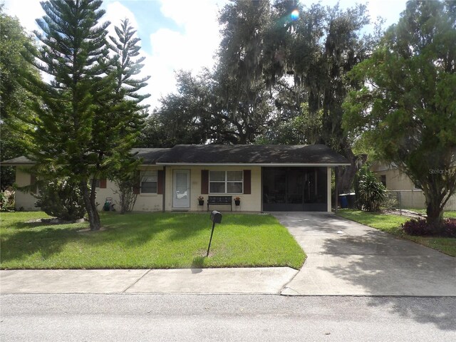 ranch-style home with a front yard and a carport