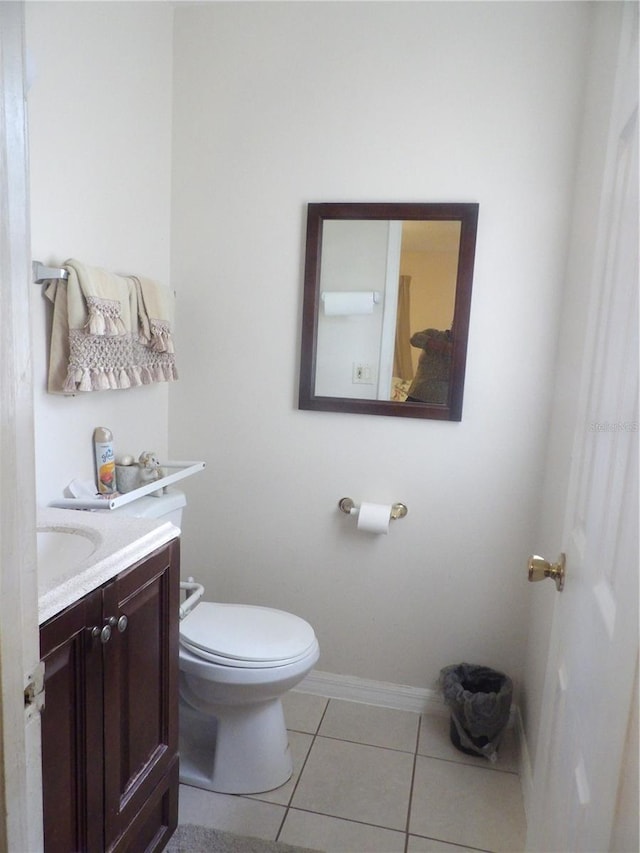 bathroom featuring vanity, tile patterned floors, toilet, and baseboards