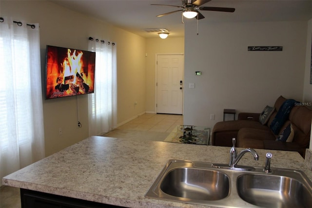 kitchen with light tile patterned floors, sink, and ceiling fan