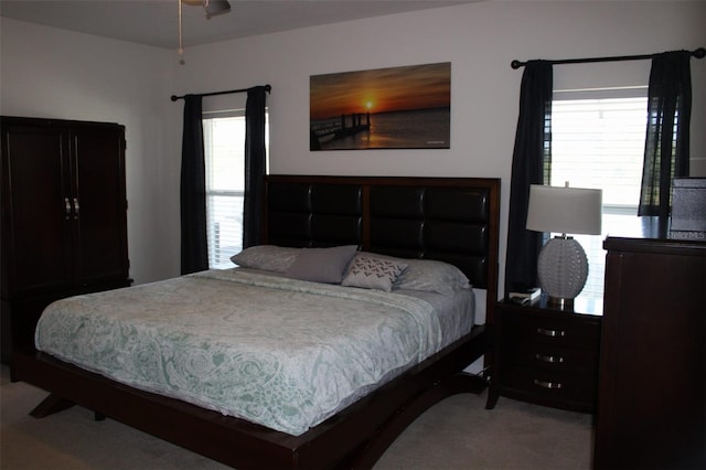 carpeted bedroom with multiple windows and ceiling fan