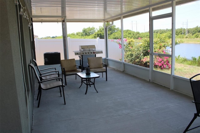 sunroom / solarium with plenty of natural light and a water view