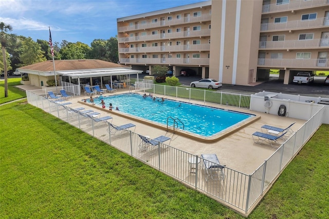 view of swimming pool featuring a patio and a lawn