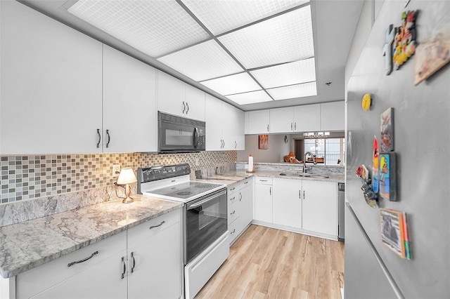 kitchen featuring light wood-type flooring, sink, white cabinetry, electric stove, and light stone countertops