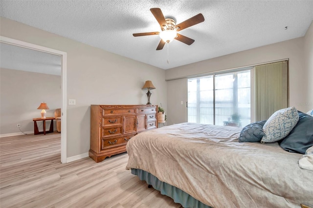 bedroom with ceiling fan, a textured ceiling, and light hardwood / wood-style flooring