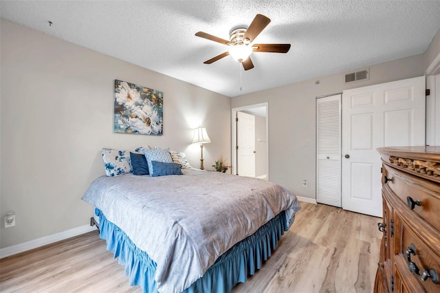 bedroom with a closet, light hardwood / wood-style floors, ceiling fan, and a textured ceiling