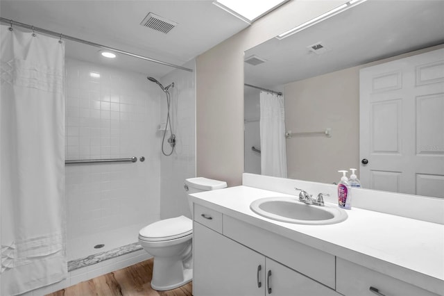 bathroom with hardwood / wood-style floors, vanity, toilet, and a shower with curtain