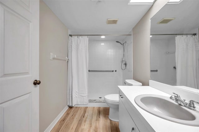 bathroom featuring wood-type flooring, vanity, toilet, and a shower with shower curtain