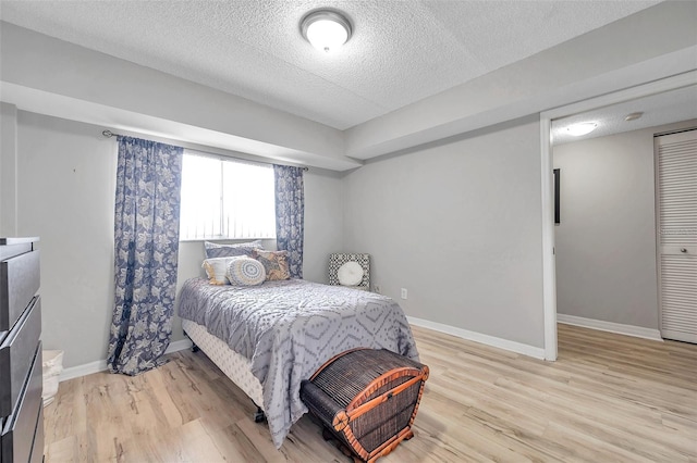 bedroom featuring a textured ceiling and light wood-type flooring