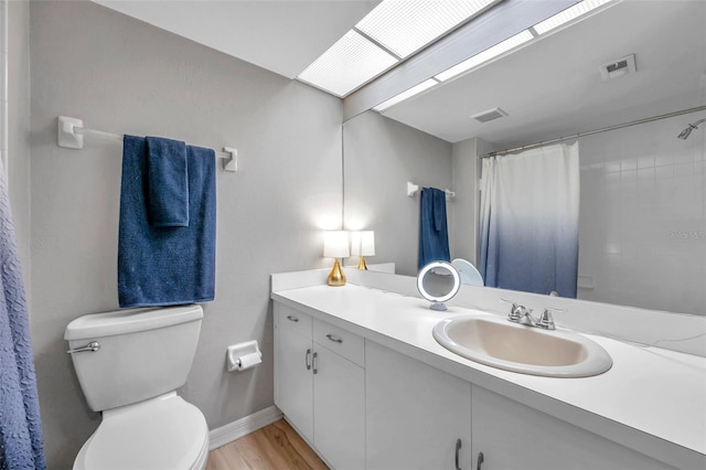 bathroom with wood-type flooring, curtained shower, vanity, and toilet