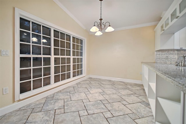 dining room with crown molding, baseboards, and an inviting chandelier