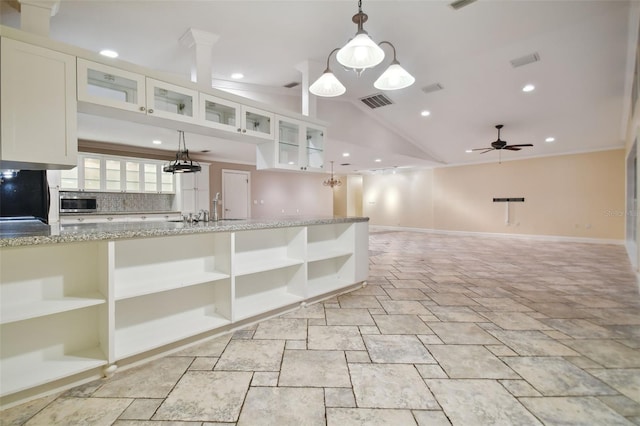 kitchen featuring white cabinetry, stainless steel microwave, visible vents, and open shelves