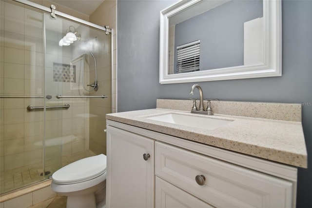 bathroom with toilet, a stall shower, and vanity