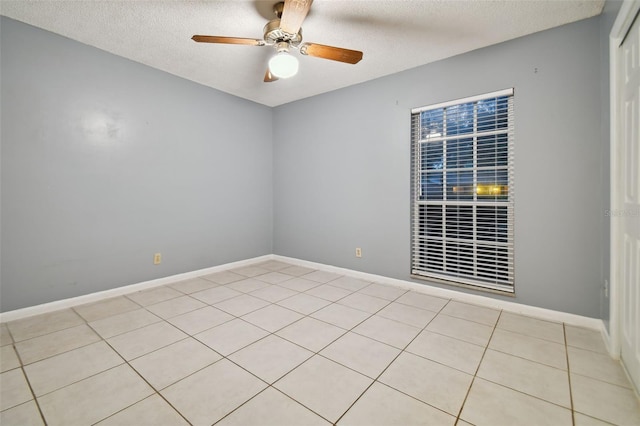 unfurnished room featuring ceiling fan, a textured ceiling, and baseboards