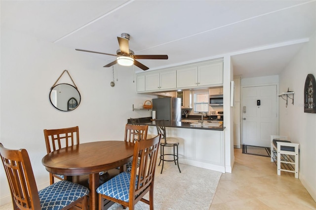 dining space featuring ceiling fan and light tile patterned floors