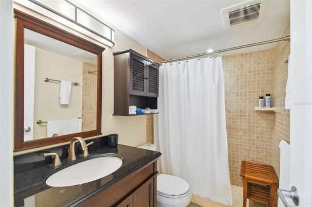 bathroom with curtained shower, toilet, a textured ceiling, and vanity