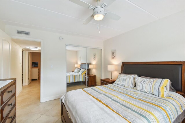 bedroom featuring light tile patterned floors, ceiling fan, and a closet