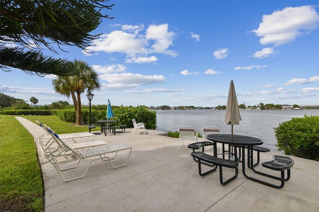 surrounding community with a water view, a lawn, and a patio