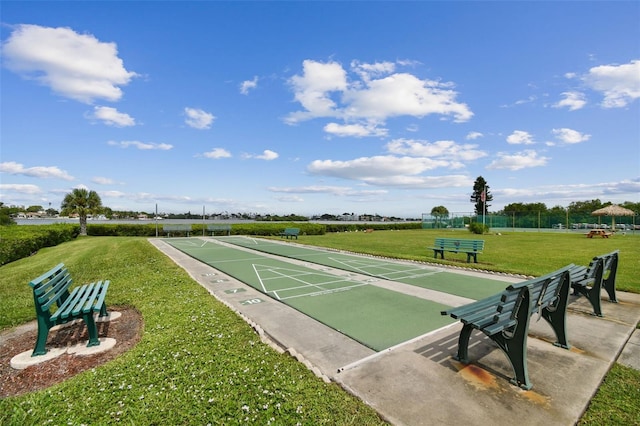 view of property's community featuring a lawn and shuffleboard