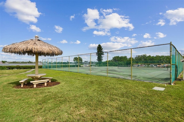 view of tennis court featuring a lawn