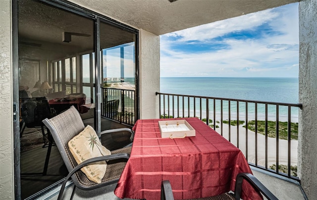 balcony featuring a beach view and a water view