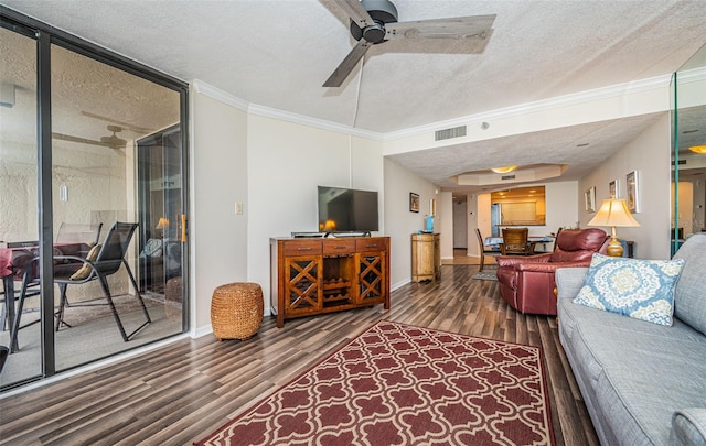 living room featuring ornamental molding, dark hardwood / wood-style flooring, ceiling fan, and a textured ceiling