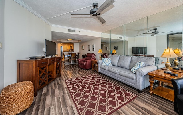 living room with dark wood-type flooring, ceiling fan, a textured ceiling, and ornamental molding