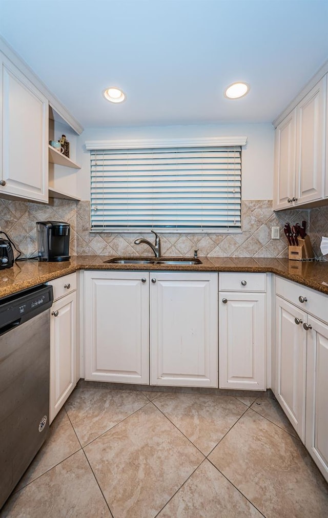 kitchen with dishwasher, light tile patterned floors, sink, white cabinetry, and dark stone countertops