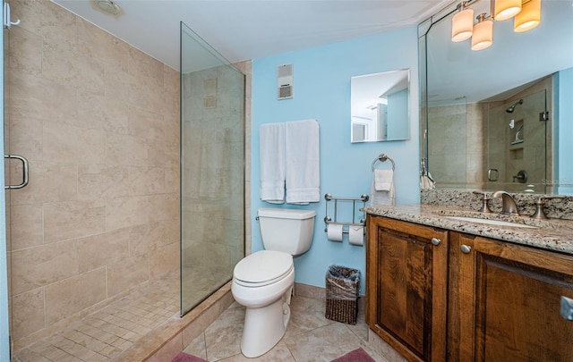 bathroom featuring vanity, toilet, tile patterned floors, and a shower with door