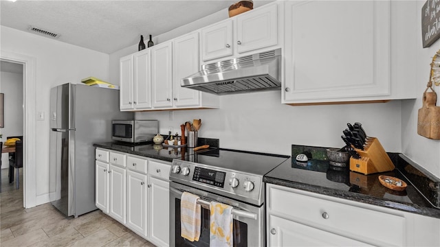 kitchen featuring dark stone counters, a textured ceiling, stainless steel appliances, and white cabinets