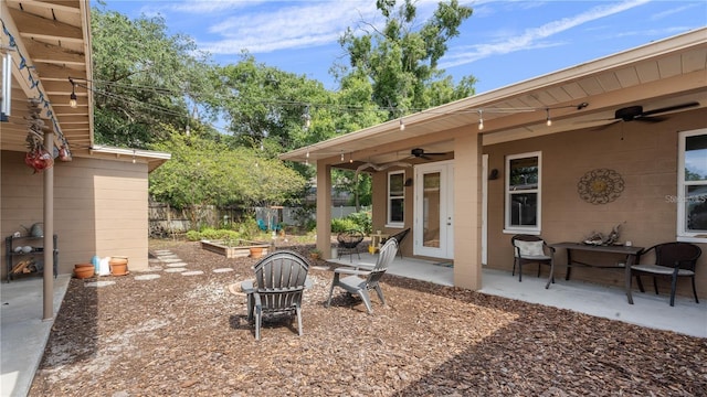 view of yard featuring ceiling fan, a patio area, and a fire pit