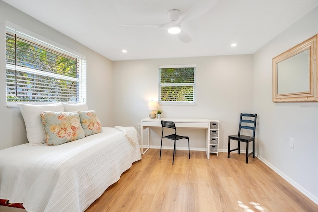 bedroom with ceiling fan, light wood-type flooring, and multiple windows